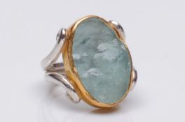 Charmian Harris. An aquamarine single-stone dress ring, the oval crystal aquamarine approximately