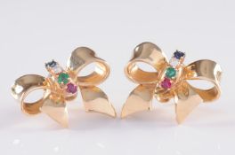 A pair of diamond, sapphire, emerald and ruby mounted ribbon bow ear studs with butterfly scrolls