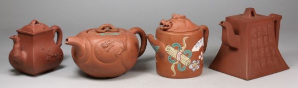 Four Yixing teapots and covers one of swelling square profile with rustic handle and bamboo spout
