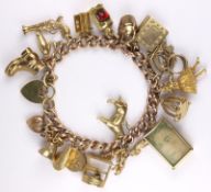 A 9ct gold curb link bracelet with various charms attached.