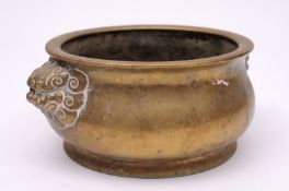 A Chinese polished bronze censer of squat baluster form with dragon mask handles, bears six