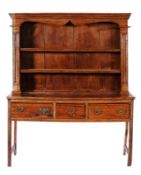 An early 19th Century fruitwood dresser, the shelved superstructure with a moulded reeded cornice