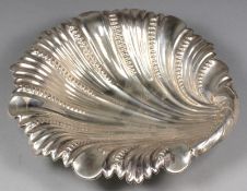 A George V silver shell shaped dish, maker’s mark worn, Sheffield, 1934, raised on ball feet, 8.