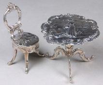 A Continental silver novelty salon chair and table, with raised decoration.