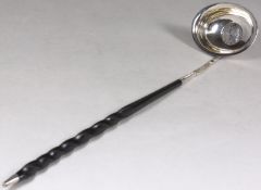 A Georgian silver punch ladle with a silver coin inset dated 1745, the handle of turned whalebone,