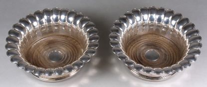 A pair of Norwegian silver plated wine coasters of circular lobed form, with ring turned wood bases,
