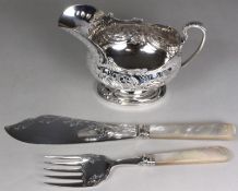 A plated gravy boat with embossed floral decoration, on an oval pedestal foot, with acanthus