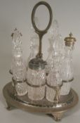 A silver plated seven division cruet stand of oval outline with central carrying handle and  glass