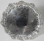 A late Victorian epns salver of circular form the centre decorated with flowerheads and foliage