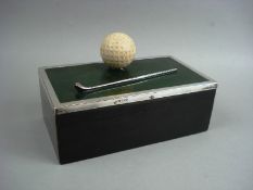 A silver mounted golf themed cigarette casket:, the top with golf ball and silver golf club on a