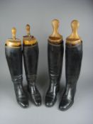 A pair of Peal & Co black leather riding boots and one other pair by Harrods: both with wooden