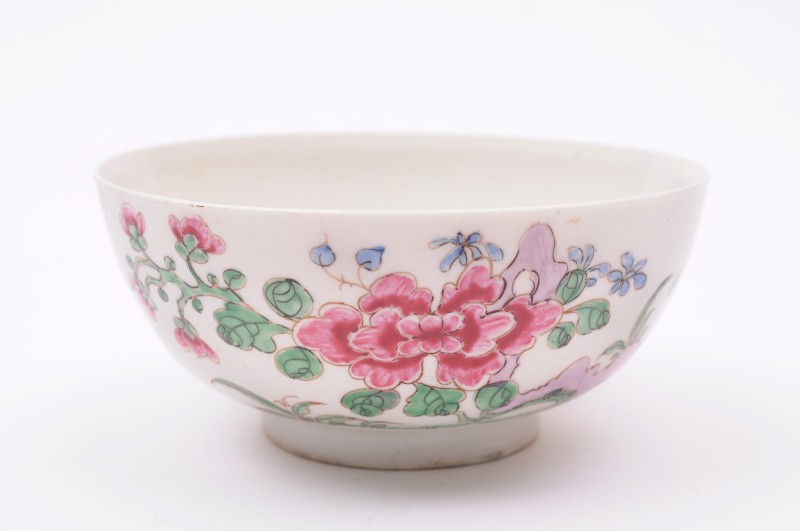 A Bow bowl painted in famille rose colours to one side with peony and rockwork, the reverse with