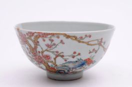 A Chinese porcelain bowl the exterior enamelled in the famille rose palette with flowering prunus