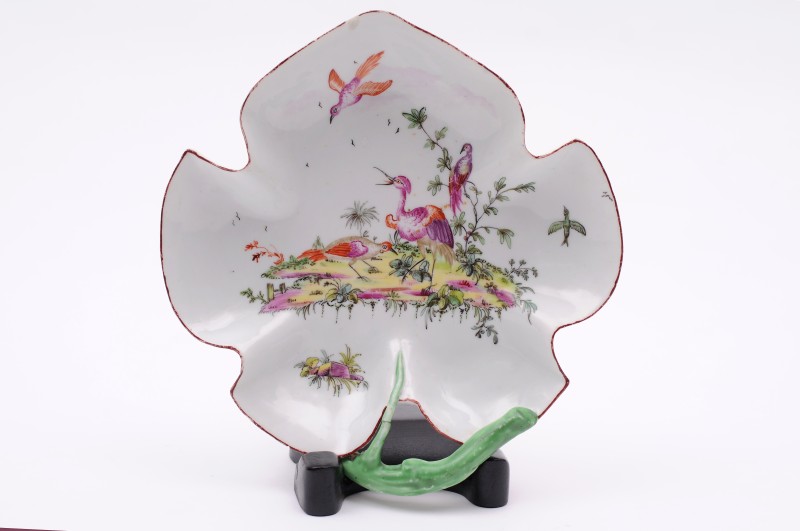 A Longton Hall leaf-shaped dish with green stalk handle, painted with five exotic birds, three