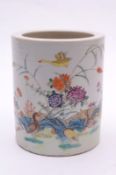 A Chinese porcelain brush pot of cylindrical form enamelled in the famille rose palette with a