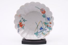 A Japanese saucer dish with fluted foliate rim, painted in the Kakiemon palette with