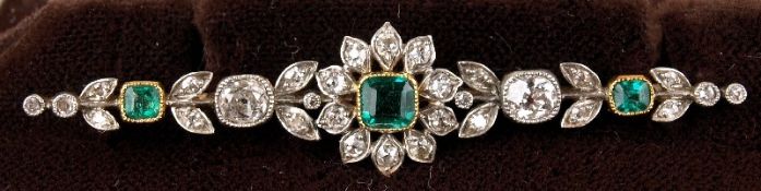 An emerald and diamond mounted floral cluster bar brooch: with round old brilliant and cushion