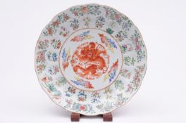 A Chinese porcelain plate of lotus moulded form the centre decorated with an iron red dragon and
