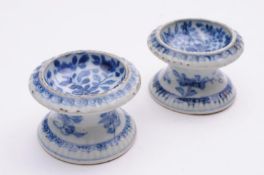 A pair of Chinese porcelain table salts each of waisted circular form with gadrooned rim and foot
