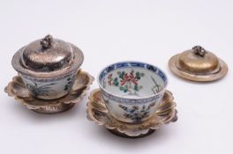 A pair of Chinese porcelain small bowls with white metal stands and domed covers with pomegranate