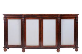 A Regency rosewood breakfront side cabinet, applied with beaded mouldings, the four doors inset with
