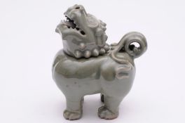 A Chinese celadon glazed incense burner in the form of a mythical lion modelled standing four square