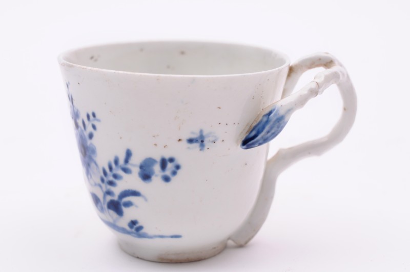 A Longton Hall coffee cup with rustic branch handle, painted in underglaze blue with a moth and