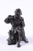 A Japanese bronze seated figure  of a peasant labourer seated on a tree trunk eating fruit from a