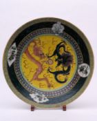 A Chinese porcelain charger the yellow ground enamelled with a green and pink three toed dragon