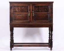 A mid 18th Century oak food cupboard on associated stand, the two doors each with S shaped piercings