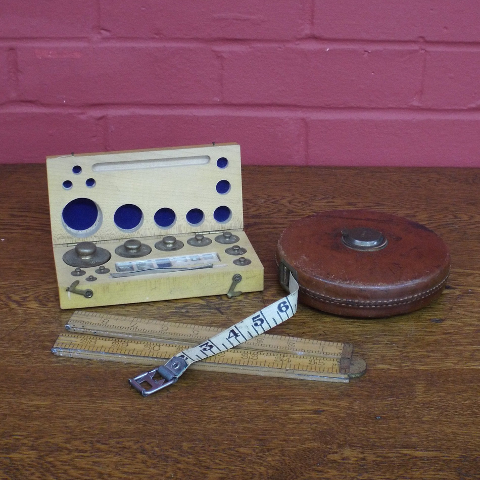 BOXED SET OF BRASS GRAMME WEIGHTS, A BOXFORD RULER AND A LEATHER CASED SURVEYORS TAPE.