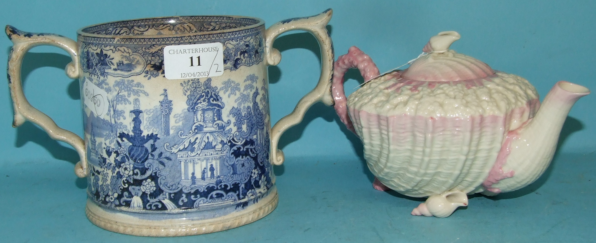 A Belleek porcelain teapot and cover, and a 19th century pottery blue transfer printed loving cup (