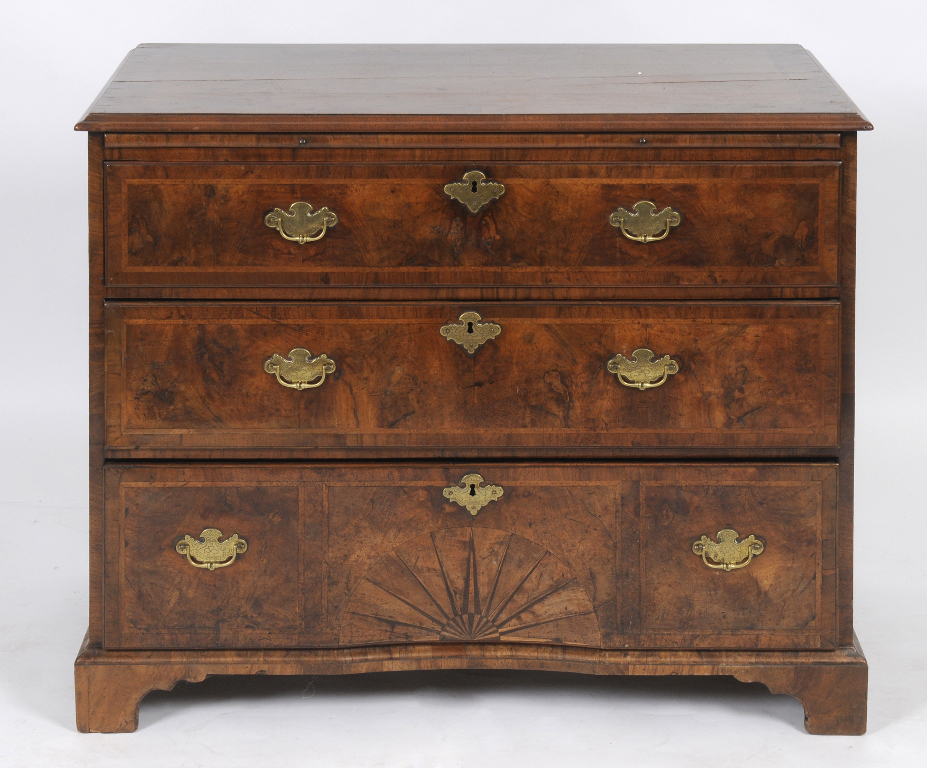 A George I chest, with a brushing slide, veneered in walnut, with feather banding, and the bottom