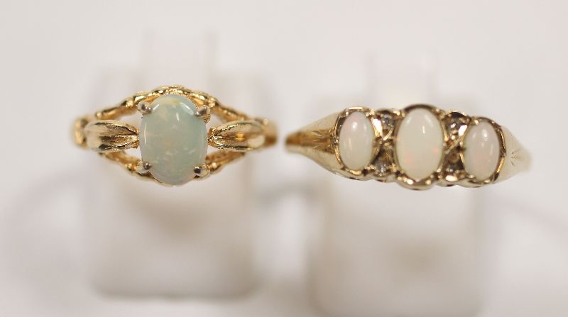 9CT GOLD 3 STONE OPAL RING APPROX SIZE Y½ AND A SINGLE OPAL RING SET ON GOLD COLOURED BAND MARKED