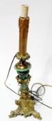 Brass and ceramic lamp base in the form of a column adorned by lion mask rings on ornate scroll