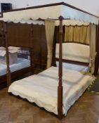 Modern dark wood four poster bed, with gold coloured curtains, gold coloured padded back board,