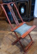 Oriental red lacquered Chinese folding campaign chair with carved slatback of dragons, with