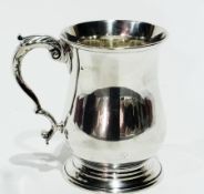 An Edwardian silver tankard, baluster shape with double 'C' scroll handle on circular foot, marks