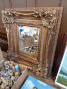 A large square gilt-framed wall mirror, foliate and scroll decoration to frame, bevelled plate