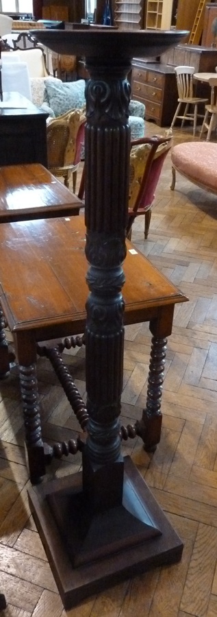 A mahogany torchere stand, circular top to foliate and reeded column to square plinth base