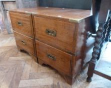 A pair of bedside campaign chests of two drawers with brass mounts to corners and brass handles , on