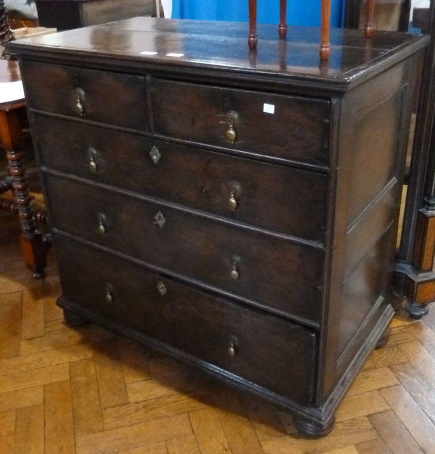18th century oak chest  of two short and three long graduated drawers, brass drop handles, on bun