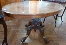 A walnut oval tilt top table, inlaid top with turned column support on four cabriole legs and