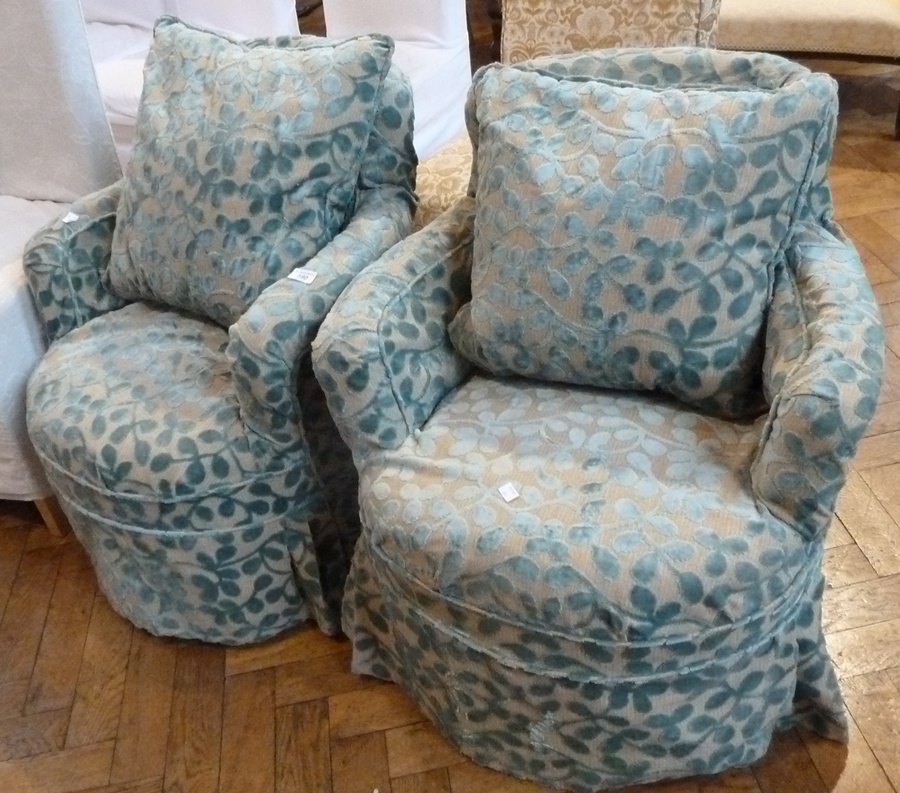 Pair Victorian upholstered tub chairs, on turned supports and castors, with loose cream covers and