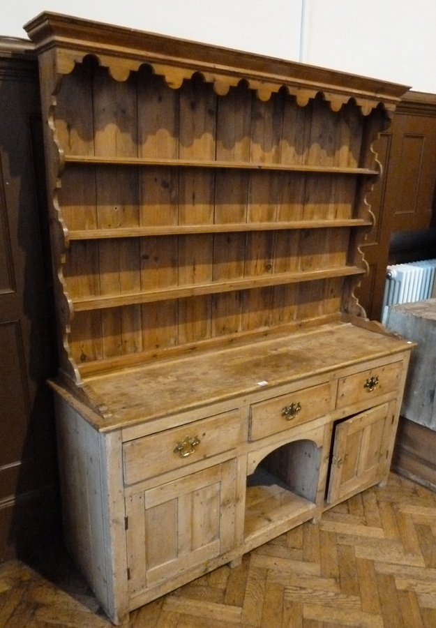 A twentieth century pine dresser, four shelves to top, three short drawers above two panelled