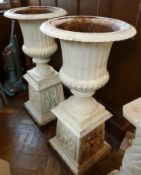 Pair white painted cast iron jardinieres, on plinth bases, urn-shaped top on square tapering