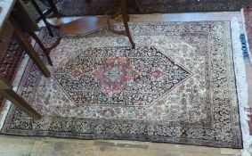 Pakistan wool rug, cream ground, with black and floral borders, central lozenge with red motif and