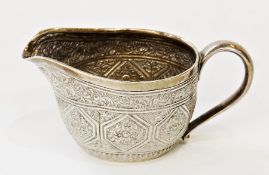 Victorian silver cream jug, heavily decorated with engraved flowers and swags, with central border