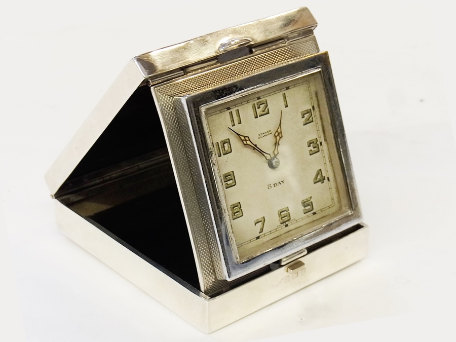 Silver travelling clock in Art Deco style engine-turned folding case, the dial inscribed "Edward,