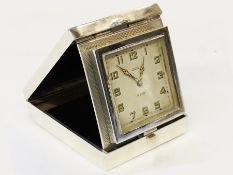 Silver travelling clock in Art Deco style engine-turned folding case, the dial inscribed "Edward,